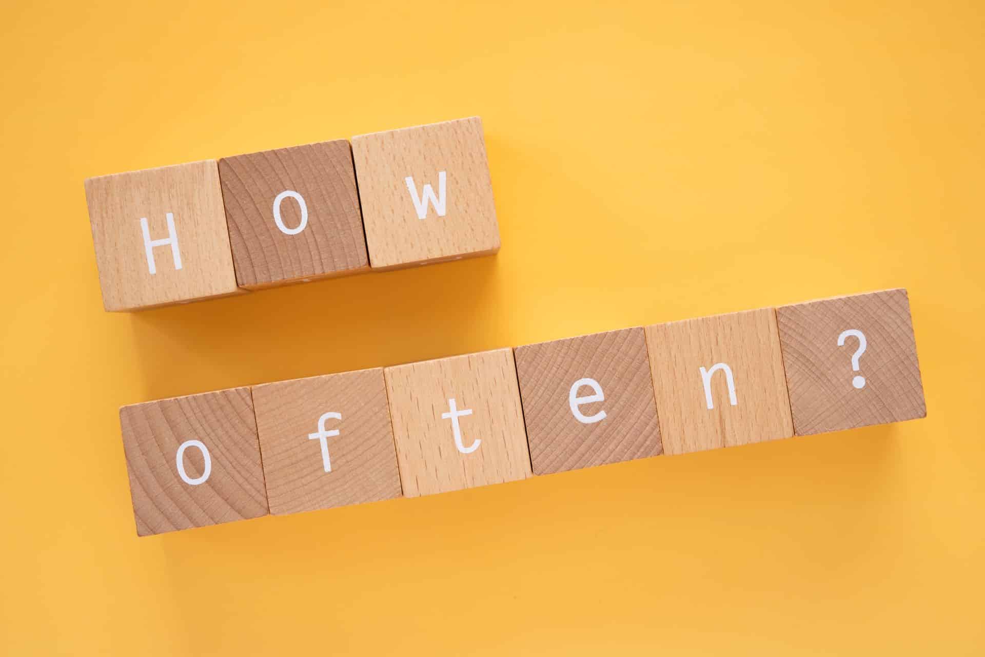 how often - The Sales Vault - The Sales Vault Wooden letter blocks spell 'HOW' above and 'often?' below on a yellow background, forming the phrase 'How often?'