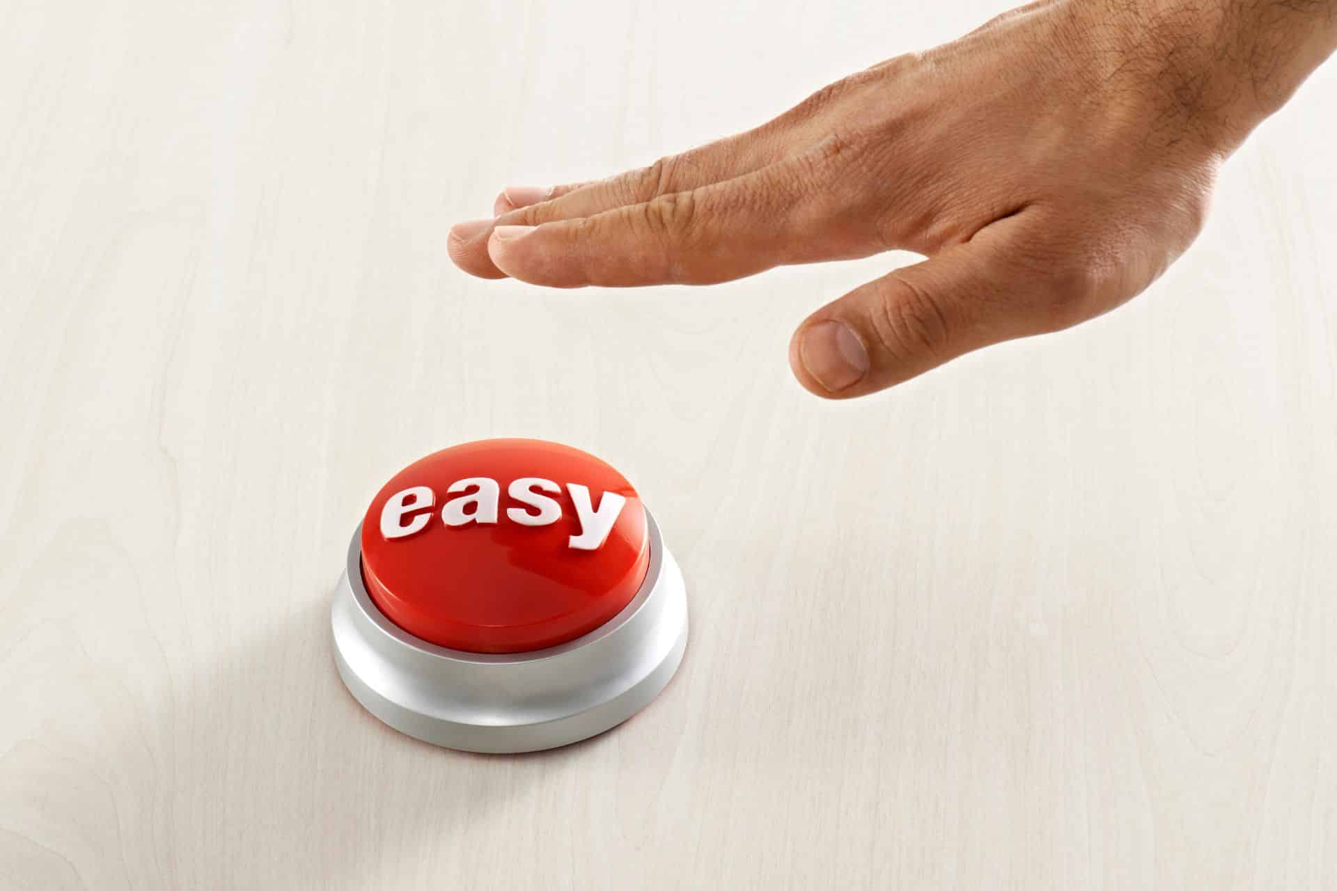 Close-up of a hand about to press a red button labeled 'easy' on a white base.